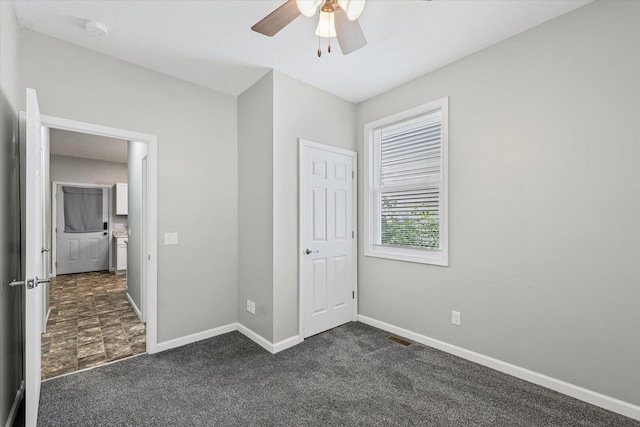 1391 W Decatur St, Decatur, IL 62522 - unfurnished bedroom with dark carpet and a ceiling fan
