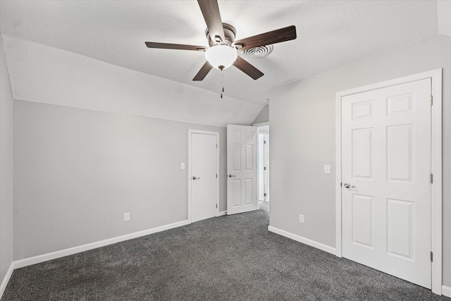 1391 W Decatur St, Decatur, IL 62522 - unfurnished bedroom featuring lofted ceiling, dark carpet, a textured ceiling, and a ceiling fan