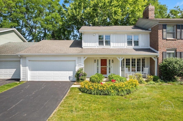 1519 Wedgefield Cir, Naperville, IL 60563 - view of front of home with board and batten siding, an attached garage, asphalt driveway, a front lawn, and covered porch