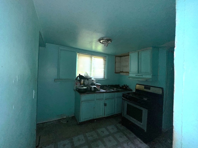 15201 Turlington Ave, Harvey, IL 60426 - kitchen featuring gas stove, dark countertops, white cabinets, a sink, and tile patterned floors
