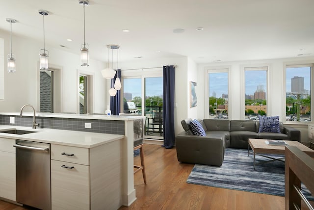 3828 N Racine Ave Unit 3, Chicago, IL 60613 - kitchen featuring dishwasher, light countertops, open floor plan, dark wood finished floors, and a kitchen bar