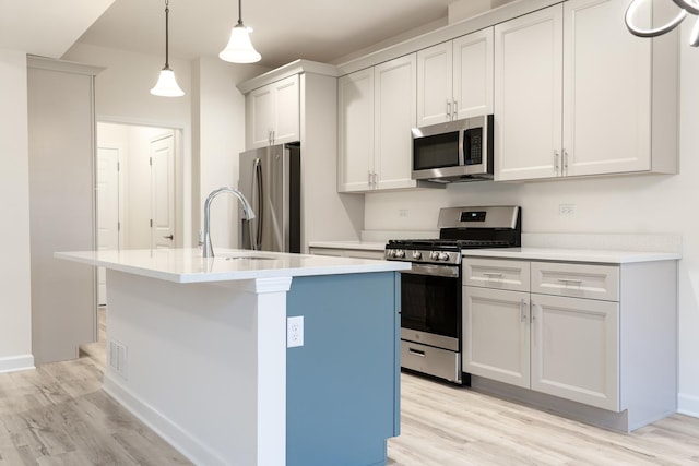 LOT15 Amherst Dr Unit B, Sycamore, IL 60178 - kitchen with stainless steel appliances, light wood finished floors, an island with sink, light countertops, and hanging light fixtures
