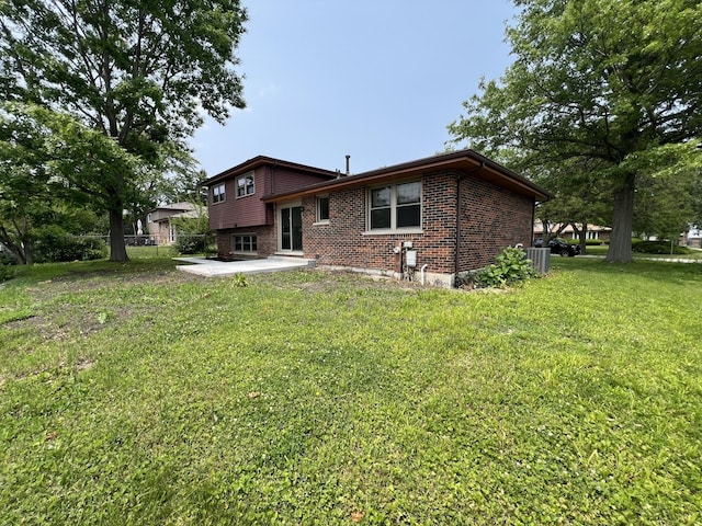 6047 Elm Ln, Matteson, IL 60443 - back of property featuring brick siding, a patio, a yard, and central AC