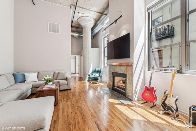 758 N Larrabee St Unit 427, Chicago, IL 60654 - living area featuring wood finished floors, a tiled fireplace, rail lighting, and a towering ceiling