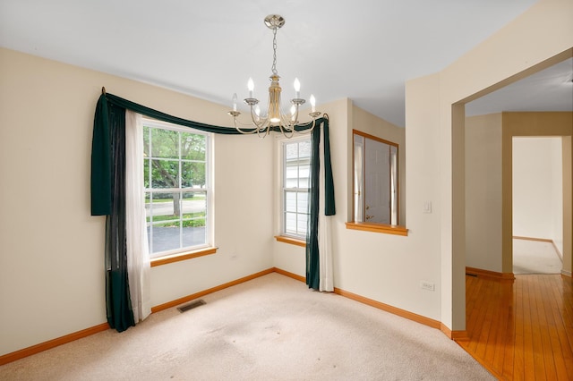 213 Stillwater Ct, Oswego, IL 60543 - empty room featuring a chandelier, plenty of natural light, and carpet flooring