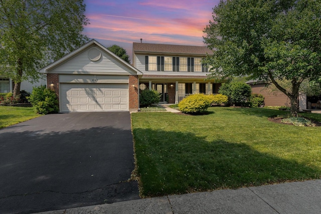 407 Anthony Ct, Oswego, IL 60543 - view of front of house featuring asphalt driveway, an attached garage, a yard, brick siding, and covered porch
