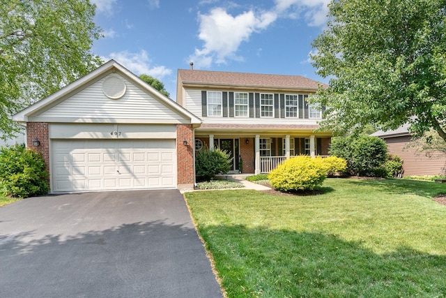 407 Anthony Ct, Oswego, IL 60543 - view of front facade with asphalt driveway, brick siding, a garage, a front yard, and covered porch