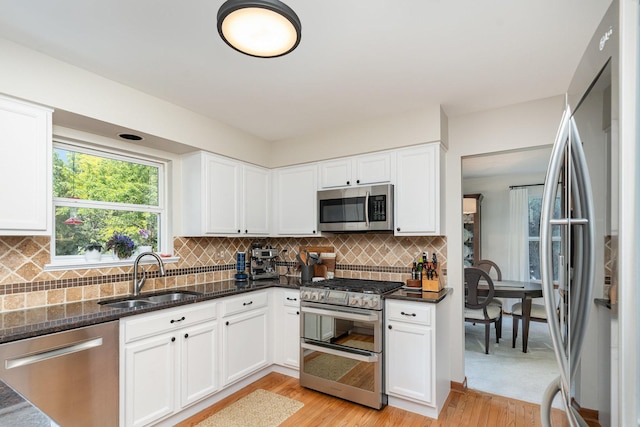 407 Anthony Ct, Oswego, IL 60543 - kitchen with appliances with stainless steel finishes, light wood-style floors, dark stone countertops, white cabinetry, and tasteful backsplash