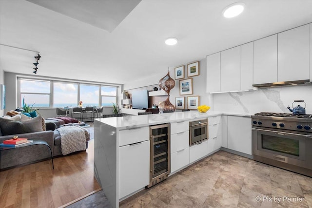 1150 N Lake Shore Dr Unit 19A, Chicago, IL 60611 - kitchen with stainless steel appliances, wine cooler, a peninsula, modern cabinets, and white cabinetry