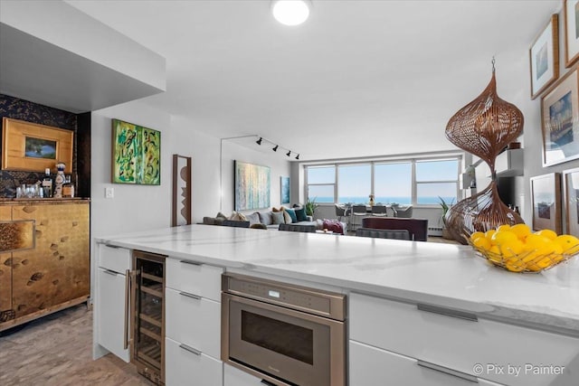 1150 N Lake Shore Dr Unit 19A, Chicago, IL 60611 - kitchen featuring wine cooler, stainless steel microwave, open floor plan, and white cabinetry