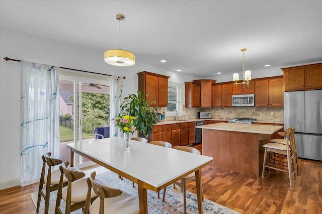 2107 Max Run Dr E, Champaign, IL 61822 - kitchen with stainless steel appliances, a center island, tasteful backsplash, dark wood finished floors, and light countertops