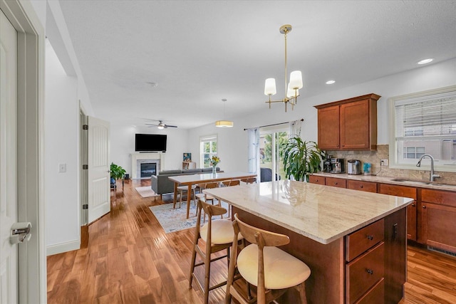 2107 Max Run Dr E, Champaign, IL 61822 - kitchen featuring a glass covered fireplace, light wood-style flooring, a center island, open floor plan, and recessed lighting