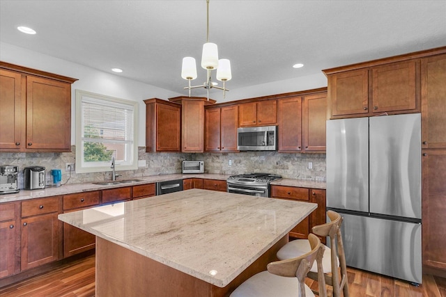 2107 Max Run Dr E, Champaign, IL 61822 - kitchen with stainless steel appliances, wood finished floors, a breakfast bar, backsplash, and recessed lighting