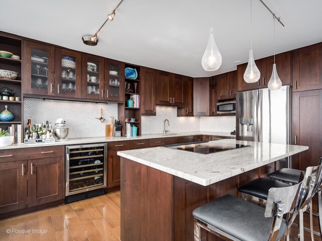 1030 N State St Unit 44L, Chicago, IL 60610 - kitchen featuring beverage cooler, appliances with stainless steel finishes, track lighting, open shelves, and a breakfast bar