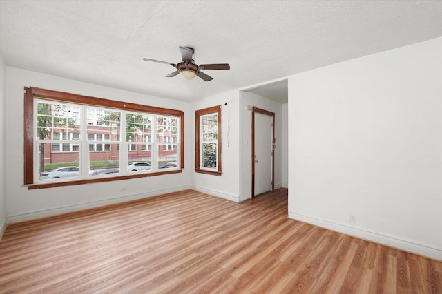 11219 S Wallace St, Chicago, IL 60628 - spare room with light wood-style floors, baseboards, ceiling fan, and a textured ceiling