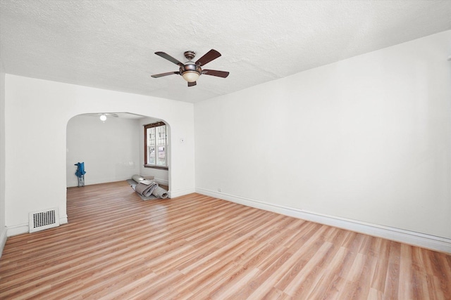 11219 S Wallace St, Chicago, IL 60628 - unfurnished room featuring arched walkways, light wood-style flooring, ceiling fan, a textured ceiling, and baseboards