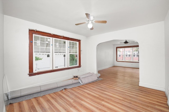 11219 S Wallace St, Chicago, IL 60628 - unfurnished room featuring ceiling fan, light wood finished floors, and arched walkways