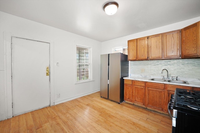 11219 S Wallace St, Chicago, IL 60628 - kitchen with stainless steel appliances, light countertops, brown cabinets, light wood-style flooring, and a sink
