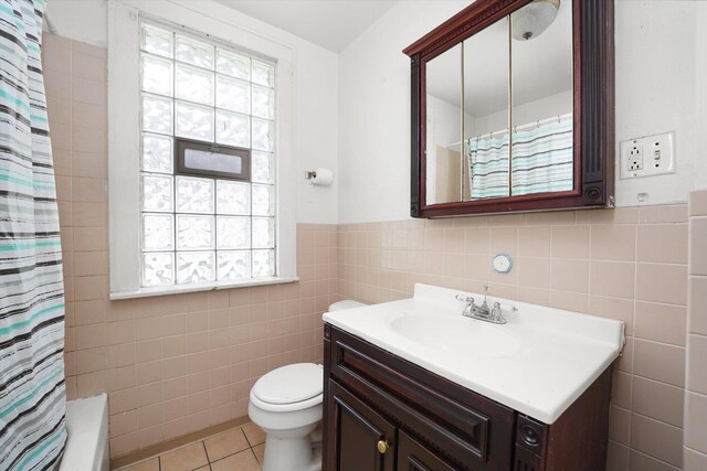 11219 S Wallace St, Chicago, IL 60628 - full bath featuring tile walls, healthy amount of natural light, vanity, tile patterned floors, and toilet