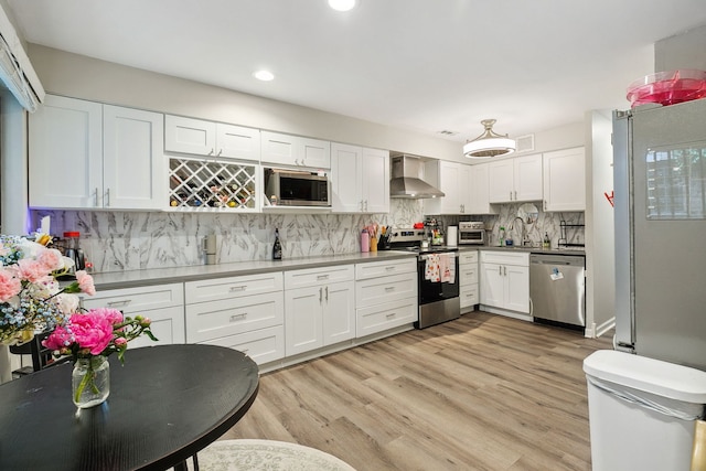 534 W Eugenie St, Chicago, IL 60614 - kitchen with stainless steel appliances, wall chimney exhaust hood, white cabinets, tasteful backsplash, and recessed lighting