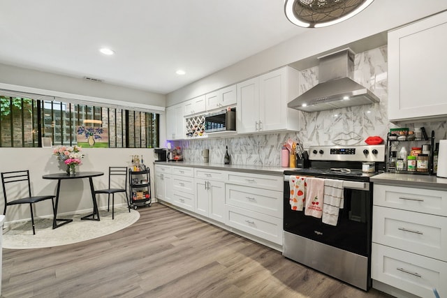 534 W Eugenie St, Chicago, IL 60614 - kitchen with wall chimney range hood, electric range, white cabinets, decorative backsplash, and light wood finished floors