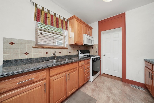 9316 S Utica Ave, Evergreen Park, IL 60805 - kitchen featuring white microwave, gas range oven, dark stone countertops, tasteful backsplash, and light floors
