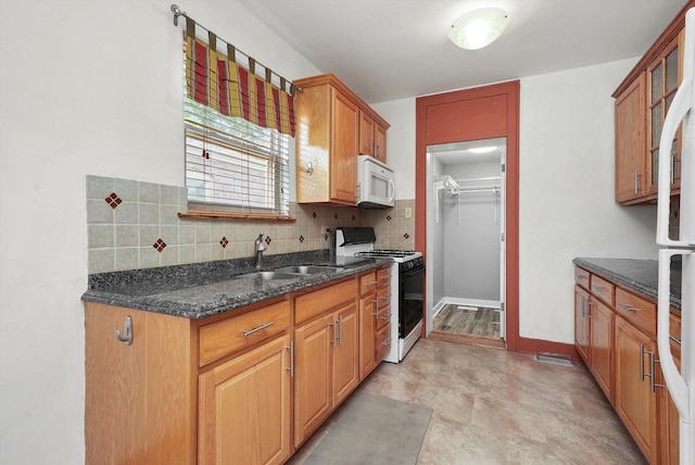 9316 S Utica Ave, Evergreen Park, IL 60805 - kitchen featuring white microwave, range with gas stovetop, tasteful backsplash, dark stone countertops, and glass insert cabinets