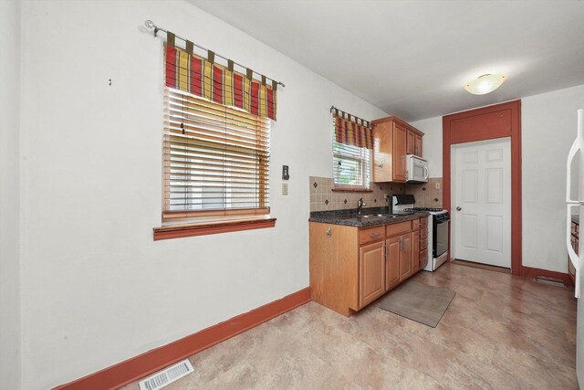 9316 S Utica Ave, Evergreen Park, IL 60805 - kitchen featuring gas range oven, white microwave, tasteful backsplash, and light floors