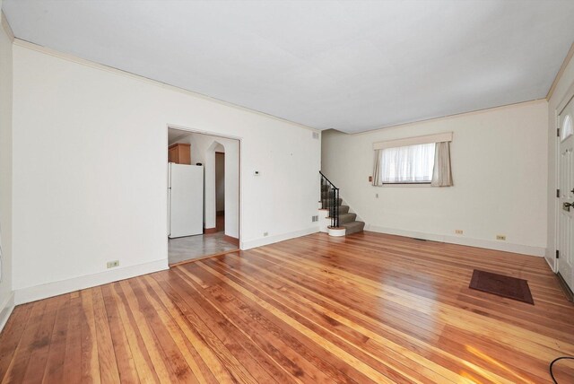 9316 S Utica Ave, Evergreen Park, IL 60805 - unfurnished living room with stairs, light wood-type flooring, and arched walkways