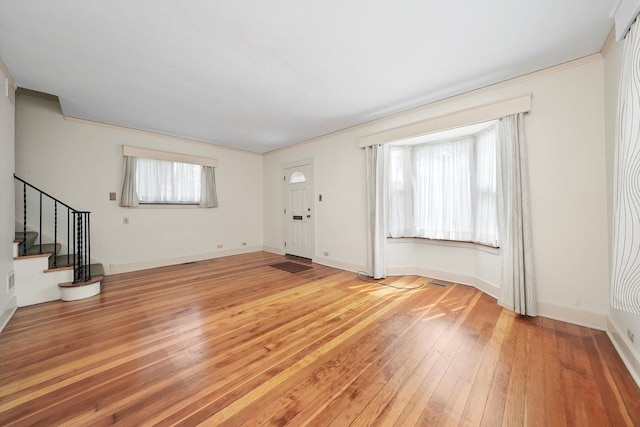 9316 S Utica Ave, Evergreen Park, IL 60805 - unfurnished living room with light wood-type flooring, stairs, and ornamental molding