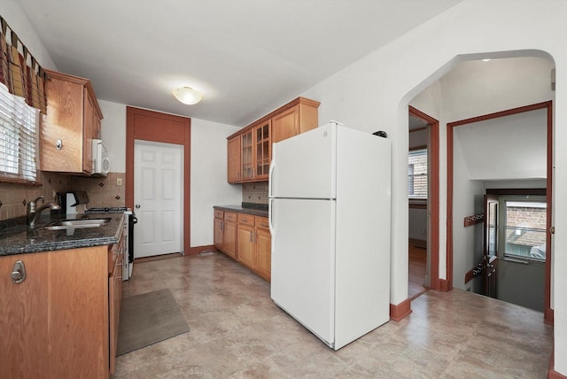 9316 S Utica Ave, Evergreen Park, IL 60805 - kitchen featuring white appliances, tasteful backsplash, glass insert cabinets, arched walkways, and plenty of natural light