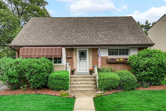 18625 Lexington Ave, Homewood, IL 60430 - view of front of home featuring brick siding, a shingled roof, and a front yard