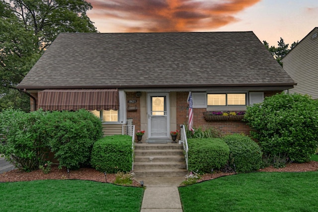 18625 Lexington Ave, Homewood, IL 60430 - view of front of house featuring brick siding, roof with shingles, and a yard