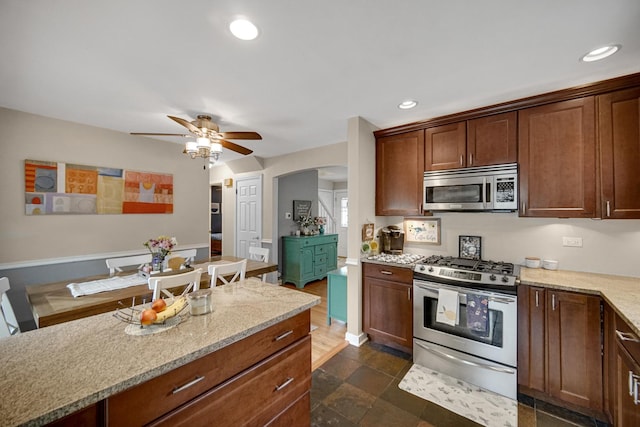 18625 Lexington Ave, Homewood, IL 60430 - kitchen with appliances with stainless steel finishes, a ceiling fan, recessed lighting, arched walkways, and light stone counters