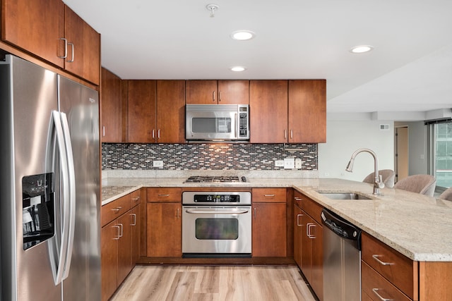 9715 Woods Dr Unit 700, Skokie, IL 60077 - kitchen with appliances with stainless steel finishes, a sink, a peninsula, light wood-type flooring, and light stone counters