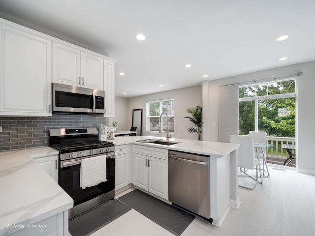 1058 Bartholdi Ct, Carol Stream, IL 60188 - kitchen with stainless steel appliances, a peninsula, recessed lighting, white cabinets, and backsplash