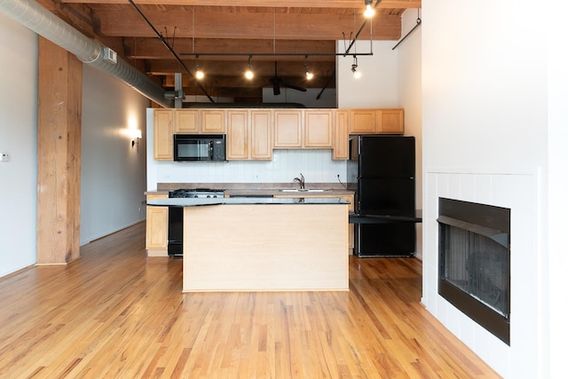 1250 W Van Buren St Unit 202, Chicago, IL 60607 - kitchen with black appliances, light brown cabinets, rail lighting, a towering ceiling, and decorative backsplash