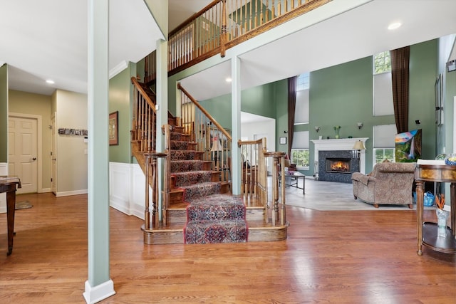 12820 Tipperary Ln, Plainfield, IL 60585 - staircase with a towering ceiling, a fireplace, wood finished floors, and recessed lighting