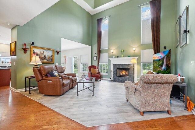 12820 Tipperary Ln, Plainfield, IL 60585 - living area with a high ceiling, light wood-type flooring, and a fireplace with flush hearth