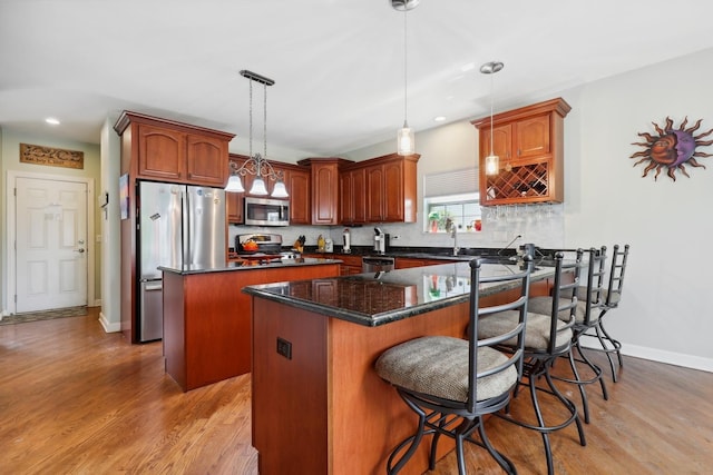 12820 Tipperary Ln, Plainfield, IL 60585 - kitchen featuring stainless steel appliances, light wood-type flooring, a peninsula, a kitchen island, and tasteful backsplash