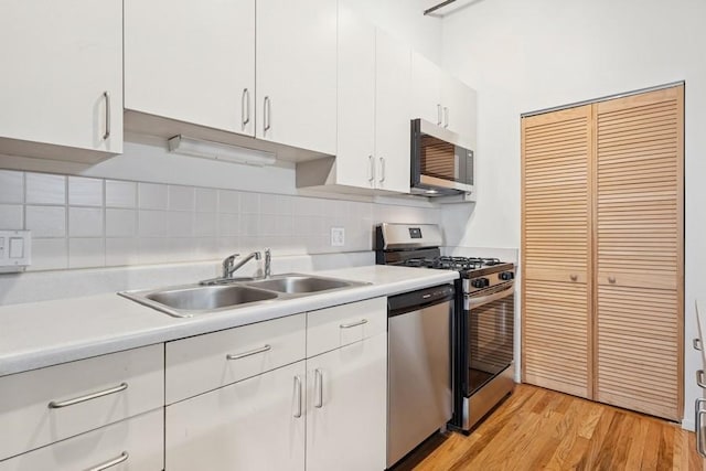 420 S Clinton St Unit 614A, Chicago, IL 60607 - kitchen with stainless steel appliances, a sink, white cabinets, light countertops, and light wood-style floors