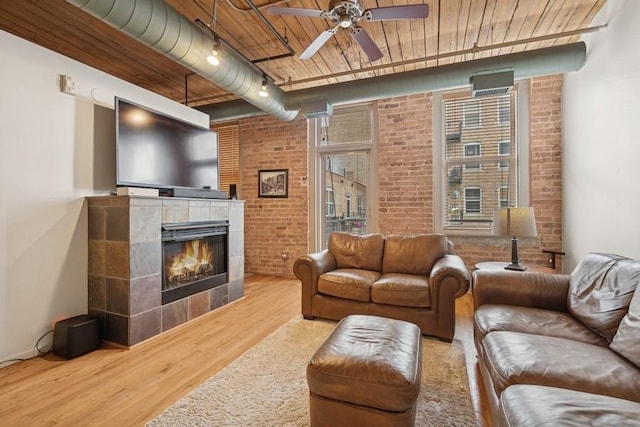 420 S Clinton St Unit 614A, Chicago, IL 60607 - living area featuring wood finished floors, brick wall, ceiling fan, wooden ceiling, and a tiled fireplace
