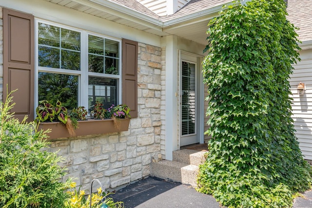 5284 Harvey Rd, Caledonia, IL 61011 - view of exterior entry featuring stone siding and a shingled roof