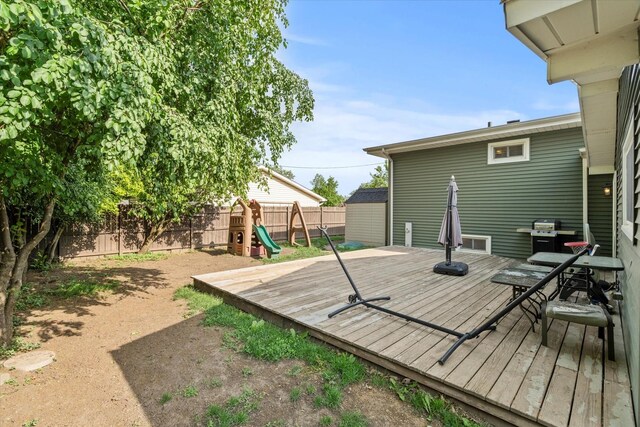 427 Cedarcrest Dr, Streamwood, IL 60107 - wooden terrace featuring a fenced backyard, a playground, outdoor dining area, and a grill