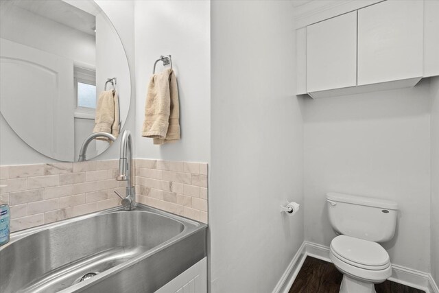 427 Cedarcrest Dr, Streamwood, IL 60107 - bathroom featuring a sink, toilet, a bath, wood finished floors, and baseboards