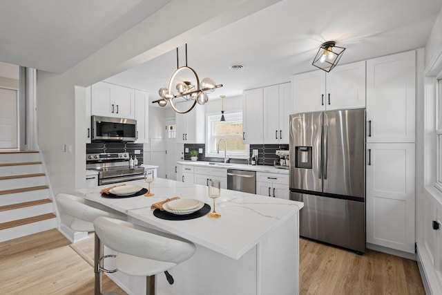 1308 Frances Pkwy, Park Ridge, IL 60068 - kitchen with stainless steel appliances, a sink, white cabinets, and light wood-type flooring