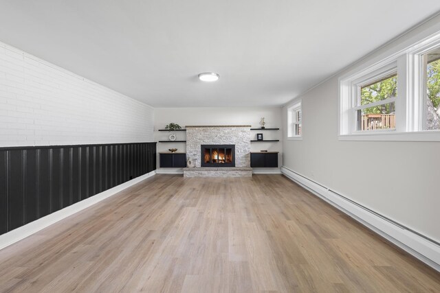 1308 Frances Pkwy, Park Ridge, IL 60068 - unfurnished living room with a baseboard radiator, light wood-type flooring, a stone fireplace, and brick wall