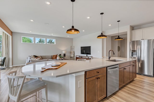 2810 Spring Cir S, Lindenhurst, IL 60046 - kitchen featuring appliances with stainless steel finishes, a sink, open floor plan, light wood-style floors, and a center island with sink