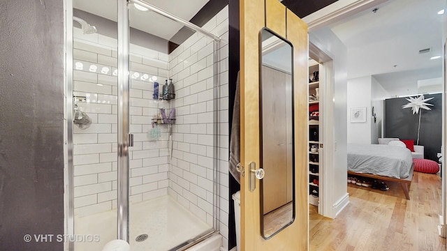 212 W Washington St Unit 1108, Chicago, IL 60606 - bathroom with a shower stall, connected bathroom, wood finished floors, and a walk in closet