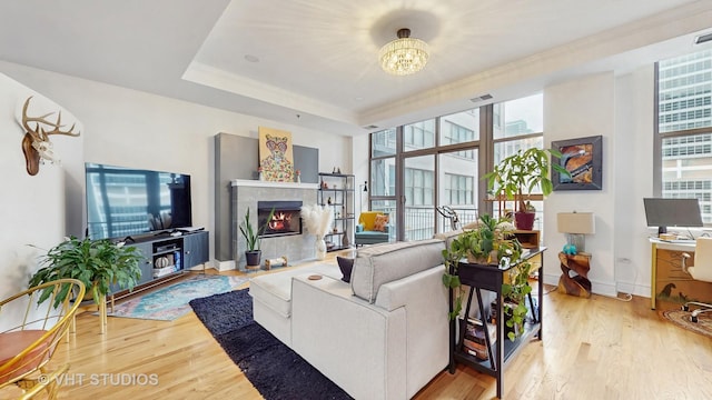 212 W Washington St Unit 1108, Chicago, IL 60606 - living room featuring wood finished floors, a fireplace, a chandelier, and ornamental molding
